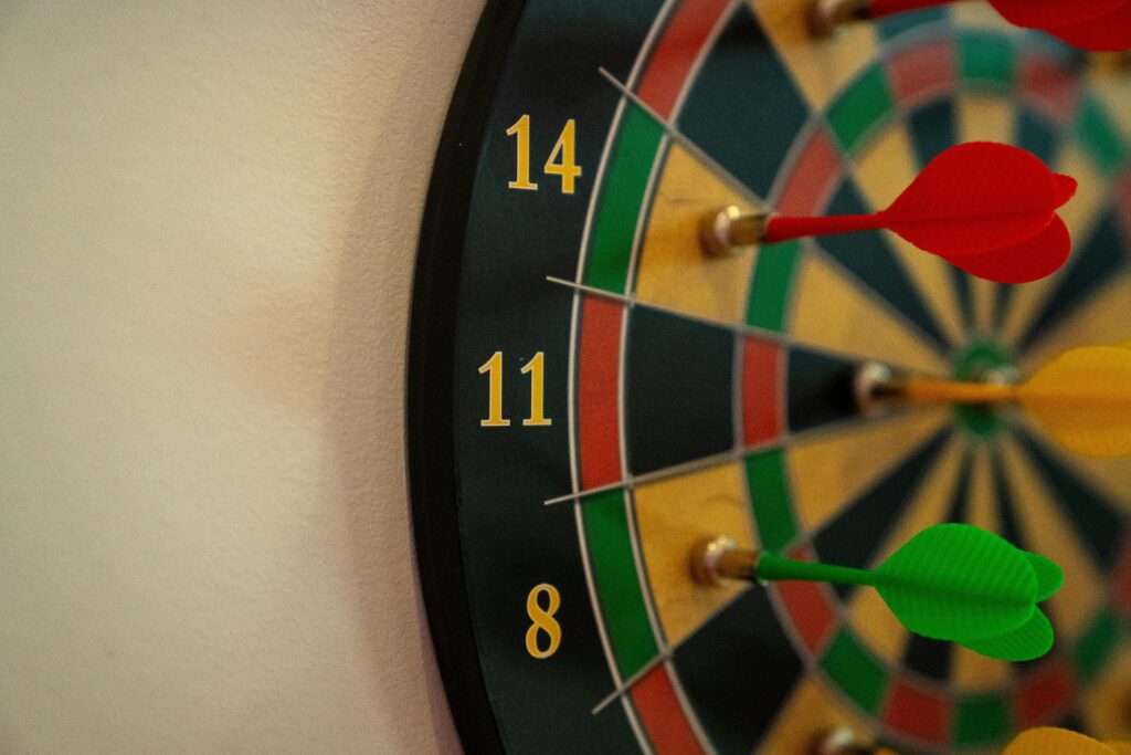 Vivid close-up of a dartboard with multicolored darts accurately striking the target.